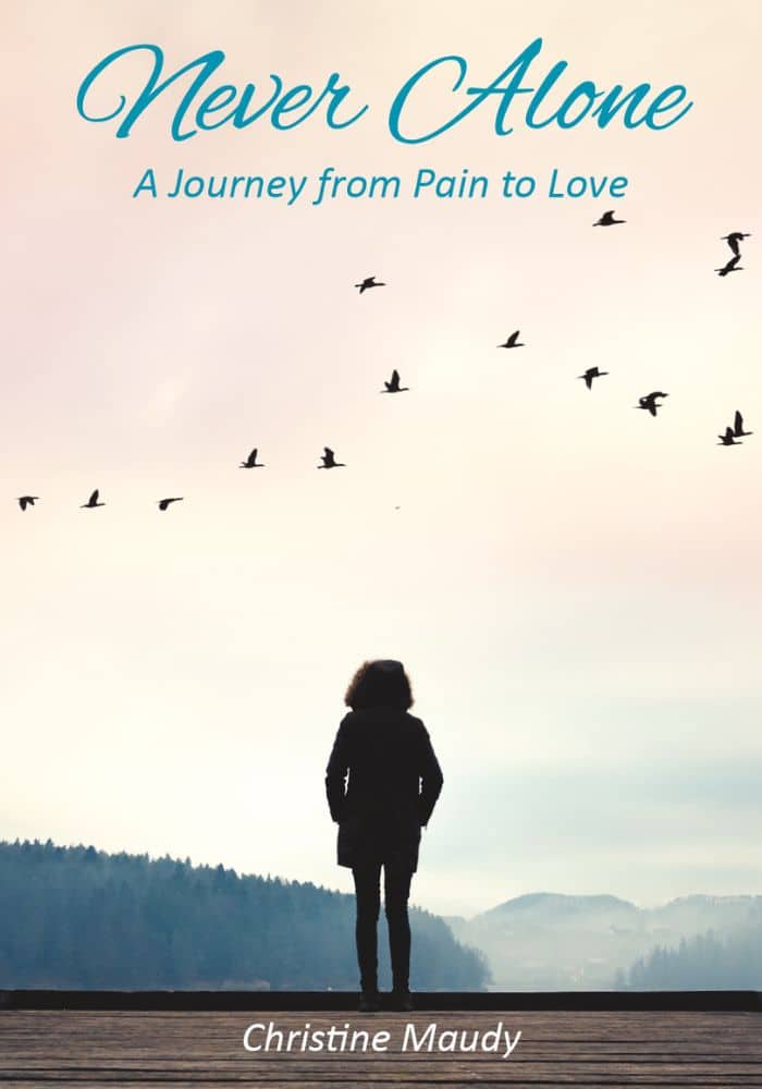 A person standing alone on a dock looking at a misty landscape with birds in flight and the title "Never Alone: A Journey from Pain to Love" with the author's name "Christine Maudy" below.